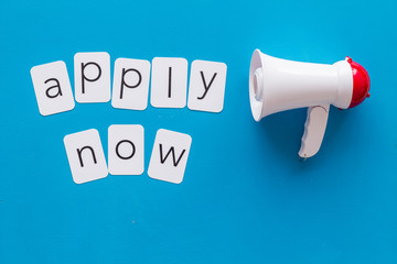 loudspeaker and apply now text for announcement on blue background top view