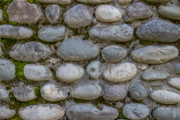 Wall of round stone and concrete on a summer day