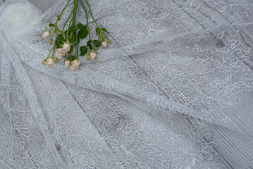 The texture of lace on wooden background decoreted roses.