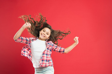Going to prom. Cute small girl with wavy prom hairstyle on red background. Adorable little child with long curly brunette hair for junior prom. Having good time at prom night, copy space
