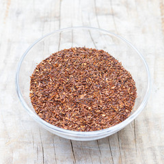 Loose tea rooibos superior in a glass cup on a wooden background
