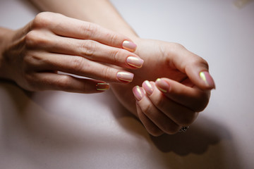Woman in salon receiving manicure by nail beautician,manicurist uses a manicure nail file to process the nail plate and nail file
