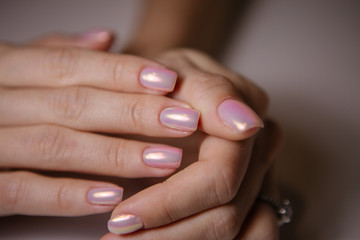 Woman in salon receiving manicure by nail beautician,manicurist uses a manicure nail file to process the nail plate and nail file