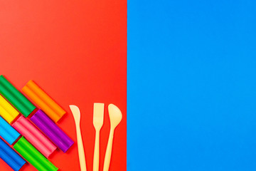 Plasticine for sculpting in different colors and a tool for working with it. Top view. Colored blocks. Copy your text