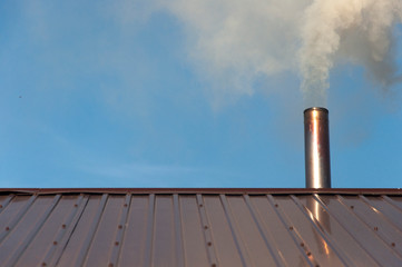 Smoke coming out the chimney against sky