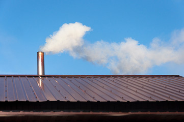 Smoke coming out the chimney against sky