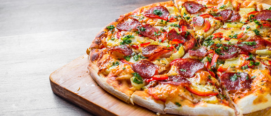 Pepperoni Pizza with Mozzarella cheese, salami, pepper. Spices and Fresh basil. Italian pizza on wooden table background - obrazy, fototapety, plakaty