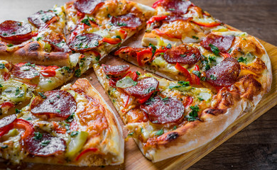Pepperoni Pizza with Mozzarella cheese, salami, pepper. Spices and Fresh basil. Italian pizza on wooden table background