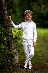 Portrait of a cute girl in a white tracksuit. Active and energetic girl having fun in summer. The concept of sports, dance, hip hop.
