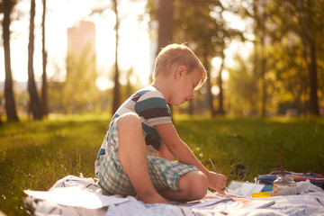 a boy of five to six years old draws in nature