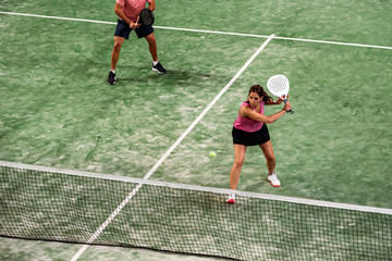 mixed padel match in a padel court indoor