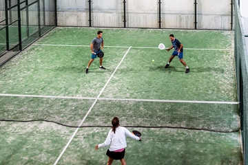 mixed padel match in a padel court indoor