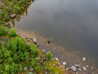 Fisherman man in river fly fishing salmon, morning
