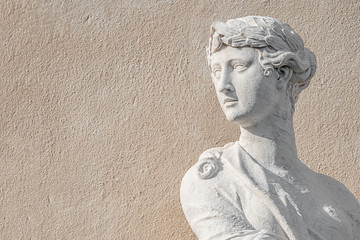 Statue of ancient sensual half naked Renaissance Era woman in Potsdam at smooth wall background, Germany