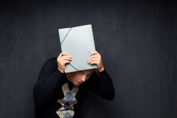 Naklejka premium Portrait of frightened man peeping from under folder