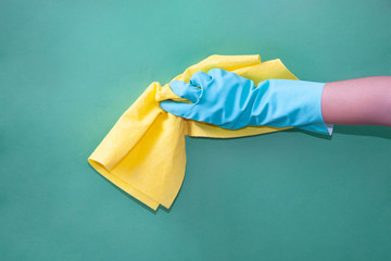 Hand in green protective glove washing a pan