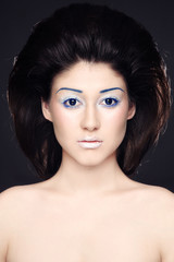 Portrait of young beautiful woman with fancy makeup and hairdo