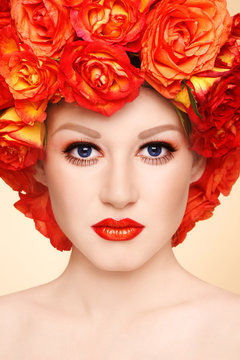 Vintage style portrait of young beautiful woman with fancy makeup and wig of orange roses