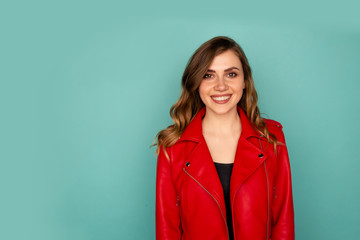 Portrait of smiling young lady with white teeth standing in a studio isolated over the blue background