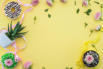 donuts on a yellow background and space for text. Childrens party concept. roses