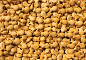 Background from a large number of small cookies in the shape of fish golden brown