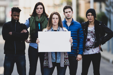 Group of five people protesting outside with signs