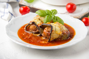 Baked eggplant rolls with meat (minced pork, beef, veal, lamb) in tomato sauce with herbs. Delicious summer food, traditional