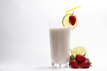 lime and ripe strawberries on a cocktail against white background
