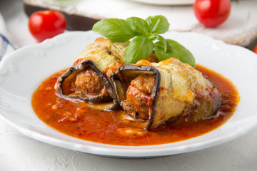 Baked eggplant rolls with meat (minced pork, beef, veal, lamb) in tomato sauce with herbs. Delicious summer food, traditional