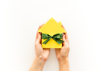 Buying a new house concept with house figure in hands on white background top view space for text