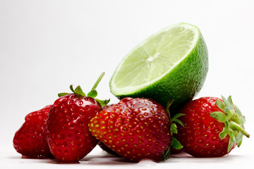 Fototapeta na wymiar lime and ripe strawberries on a white background