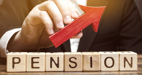 Wooden blocks with the word Pension and up arrow. Improving the financial condition of older...