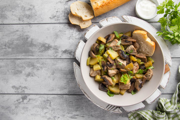 Roast meat (pork, beef) with potatoes, zucchini and mushrooms. Autumn fried stew with sour cream and parsley, traditional food, hearty tasty lunch