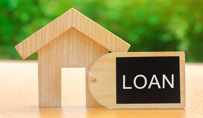 Miniature house with the word Loan. The concept of mortgage housing and real estate loans. Buy an apartment on credit. Leasing. Affordable Housing for young families. Interest rates