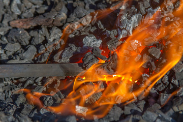 flames and hot coals with blacksmith tool