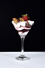 dessert in bowl with fruits on black background.