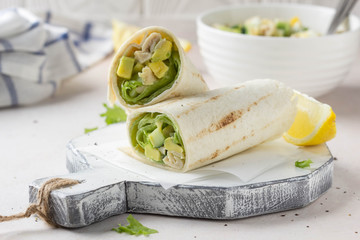 Grill roll of flatbread stuffed with avocado, cucumber, egg and white meat (chicken, squid, fish). Delicious lunch, snack, fast food, healthy food - obrazy, fototapety, plakaty