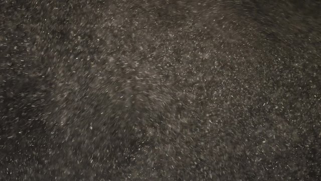 White particle dust flying around against black background