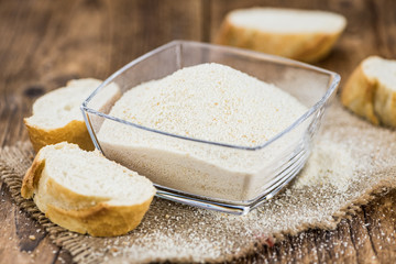 Some fresh Bread Crumbs on wooden background (selective focus; close-up shot)