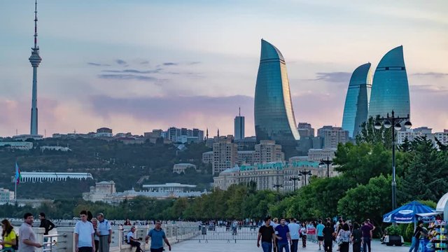 Unidentified people walking with background of panoramic cityscape view of Baku, Hyperlapse video, capital city of Azerbaijan on sunset light