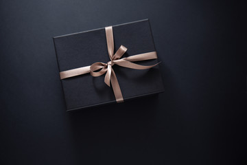 Gift wrapped in dark paper on dark background