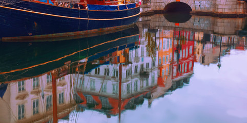 Reflection in water of  Nyhavn pier with color buildings in the old part of town of Copenhagen, Denmark