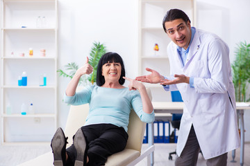 Old woman visiting young doctor dentist