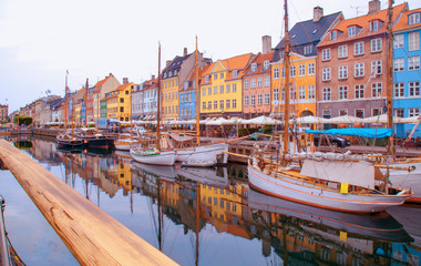 Fototapeta na wymiar Summer morning view of Nyhavn pier with color buildings, ships, yachts and other boats in the old part of town of Copenhagen, Denmark. Editorial image.