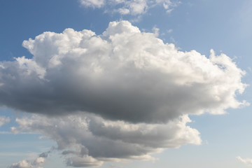 Blue sky with white clouds. Big dark cloud on the blue sky. Cloudy daytime weather. Background with free space and empty place.