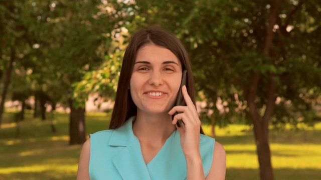 caucasian girl front view looking camera smiling phone friend nature outdoors background