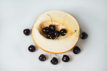 Composition on white background with fruit. Melon and cherrys