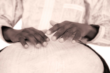 Djembe player using his musical instrument, sepia tone