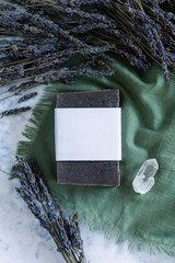 natural bar soap made with lavender essential oil on a green cloth with a crystal, handmade soap, handmade soap with blank label, mockup label flat lay