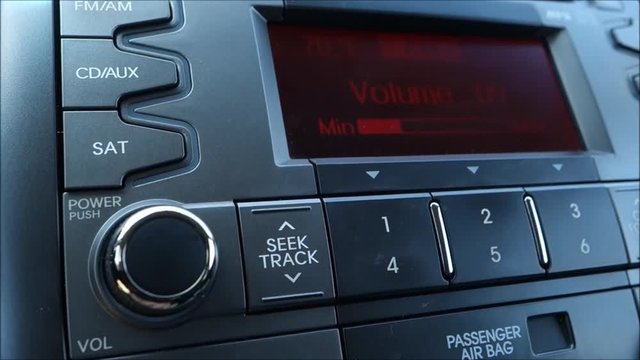 Person Turning Up Volume On Car Radio